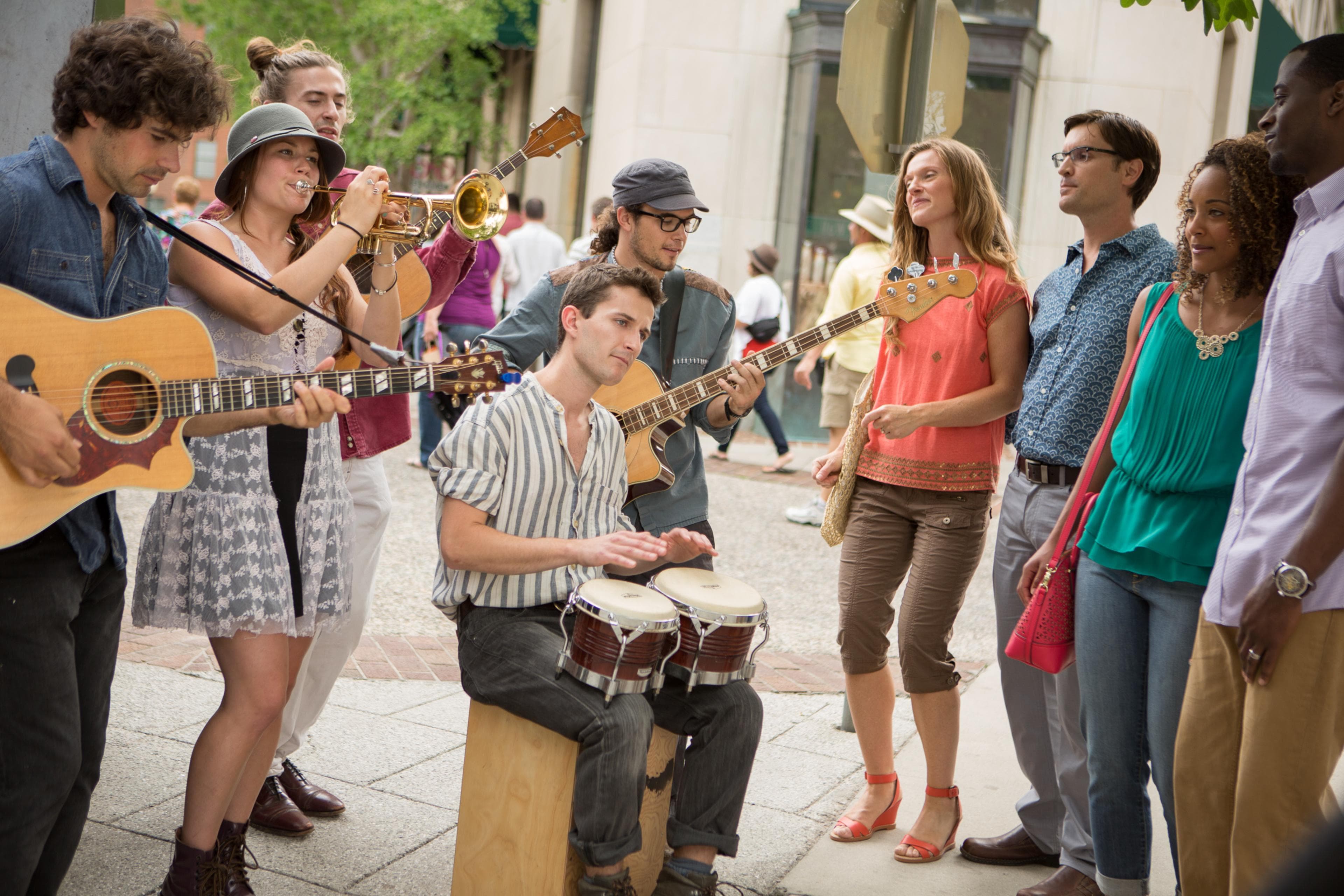 Asheville's Busking Scene Keeps Music in the Air A busker sits amid other musicians and an audience playing the bongos in Asheville