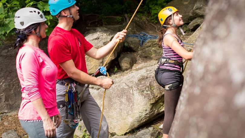 Three people prepare to climb a rock facing in Asheville, NC. Three people prepare to climb a rock facing in Asheville, NC.