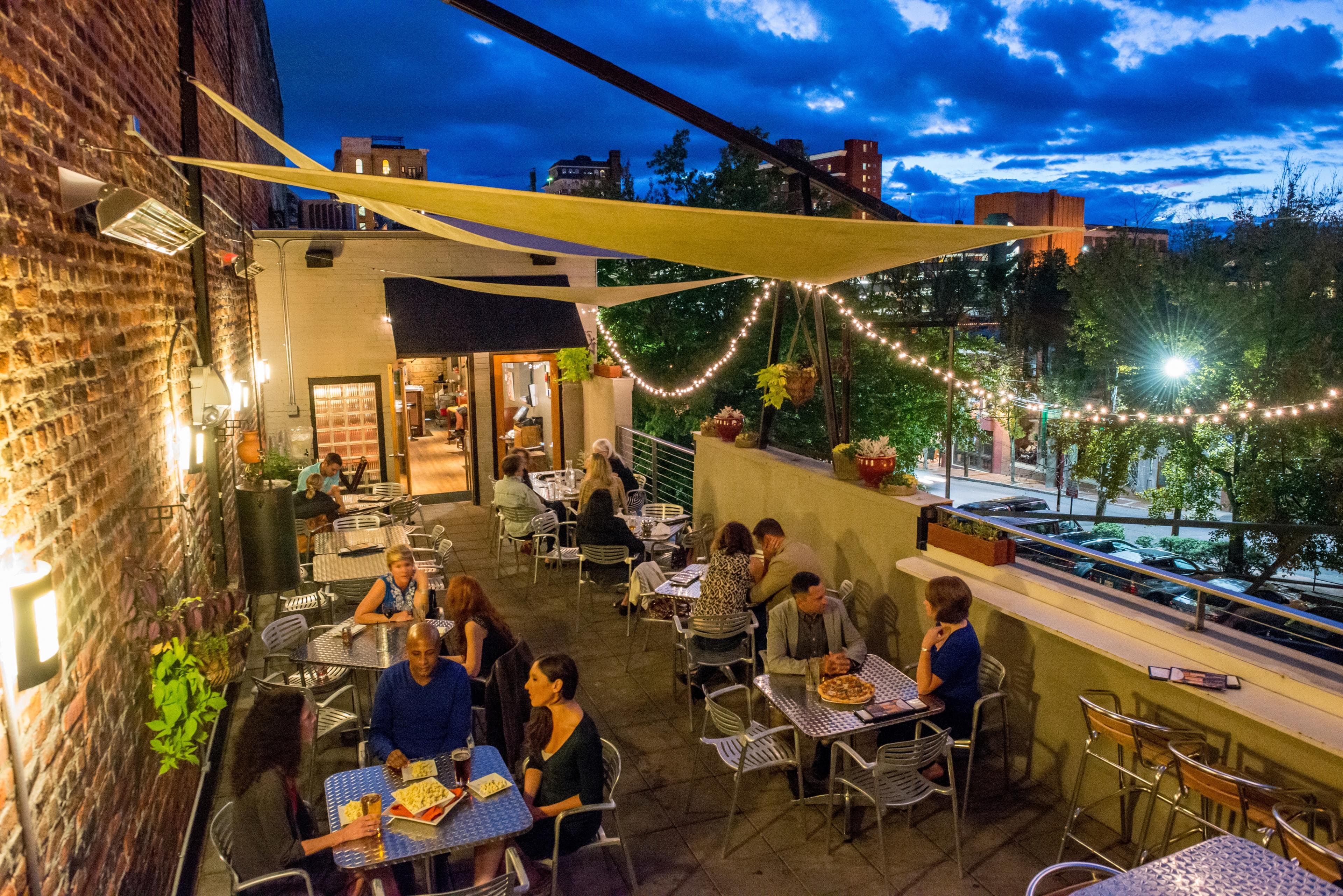 Late Night Things to Do in Asheville People sit at tables on an outdoor patio in Asheville