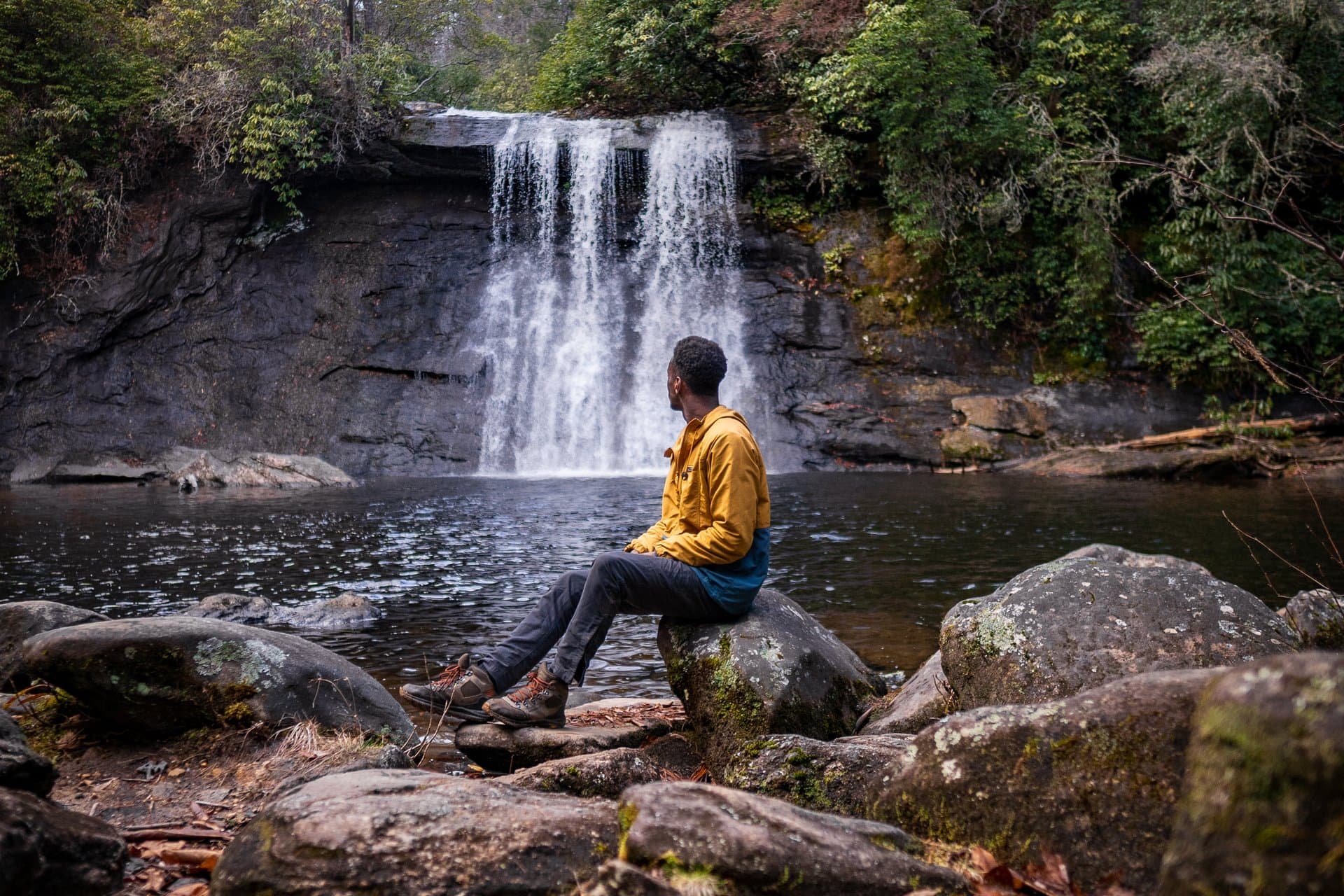 Things to Do Man sitting on a rock at Silver Run Falls
