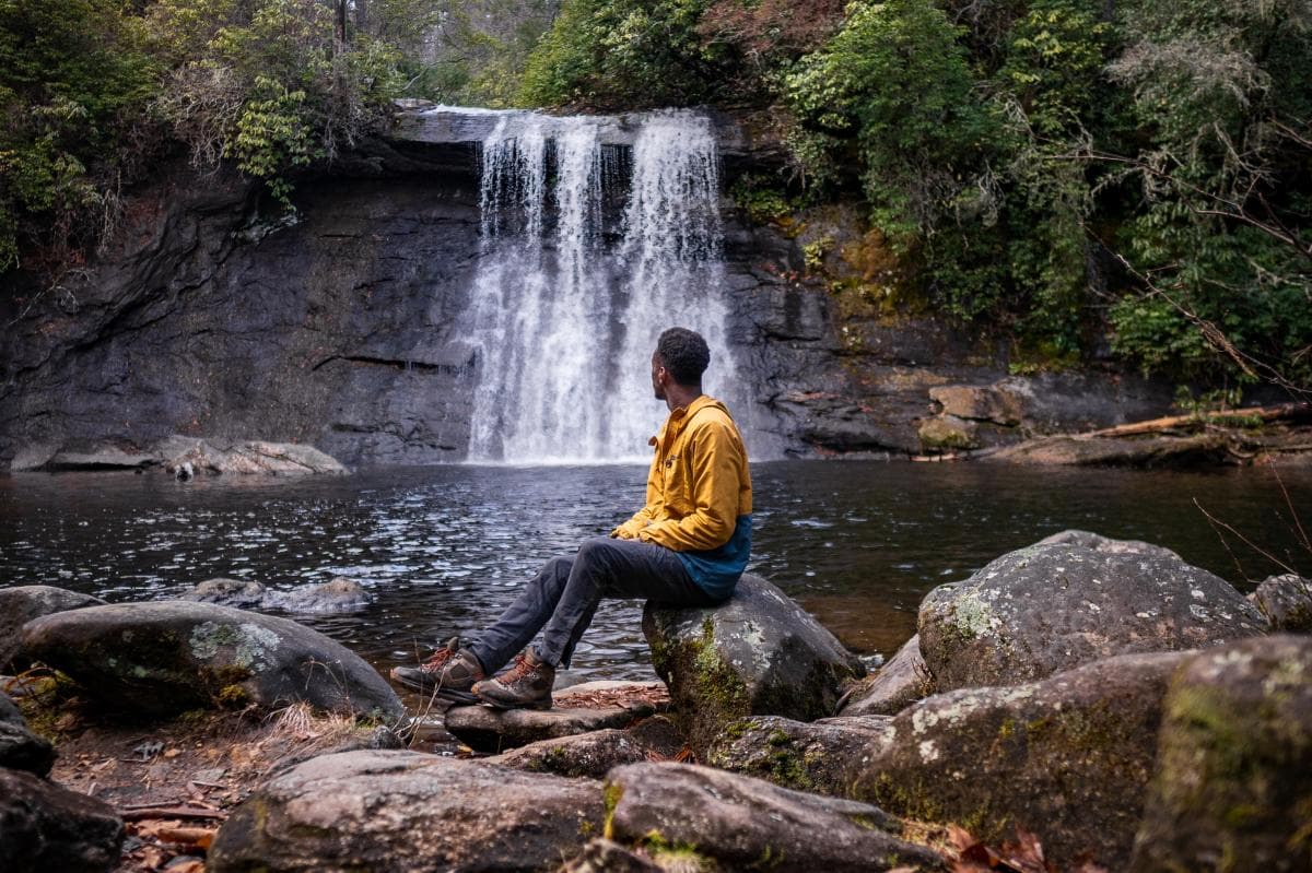 Hiker sitting in front of Silver Run Falls waterfall Hiker sitting in front of Silver Run Falls waterfall