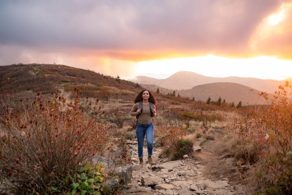 Hiker on top of Black Balsam during sunset with fall colors Hiker on top of Black Balsam during sunset with fall colors