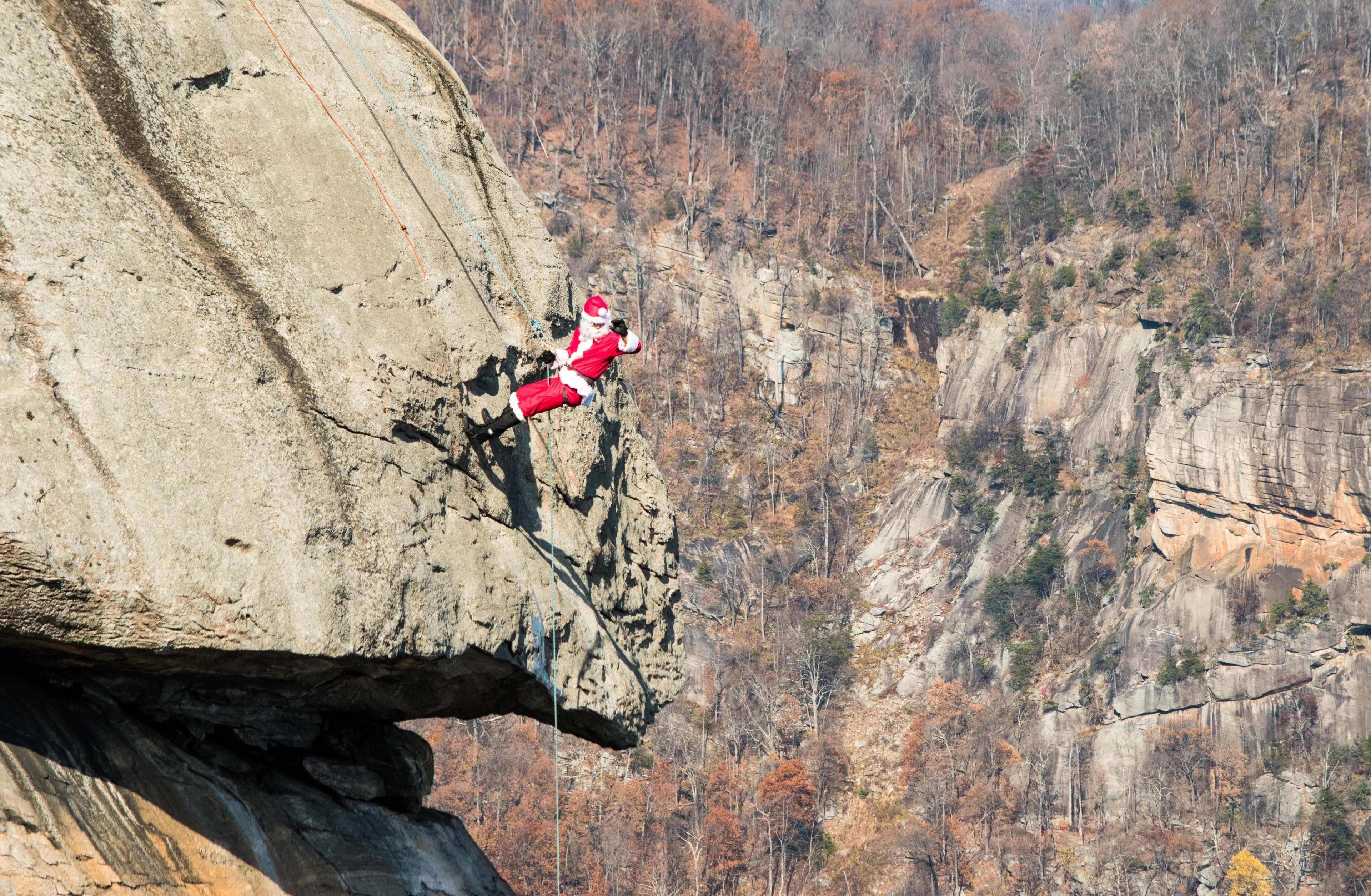 Santa on the Chimney at Chimney Rock State Park A person dressed up as Santa repels down Chimney Rock