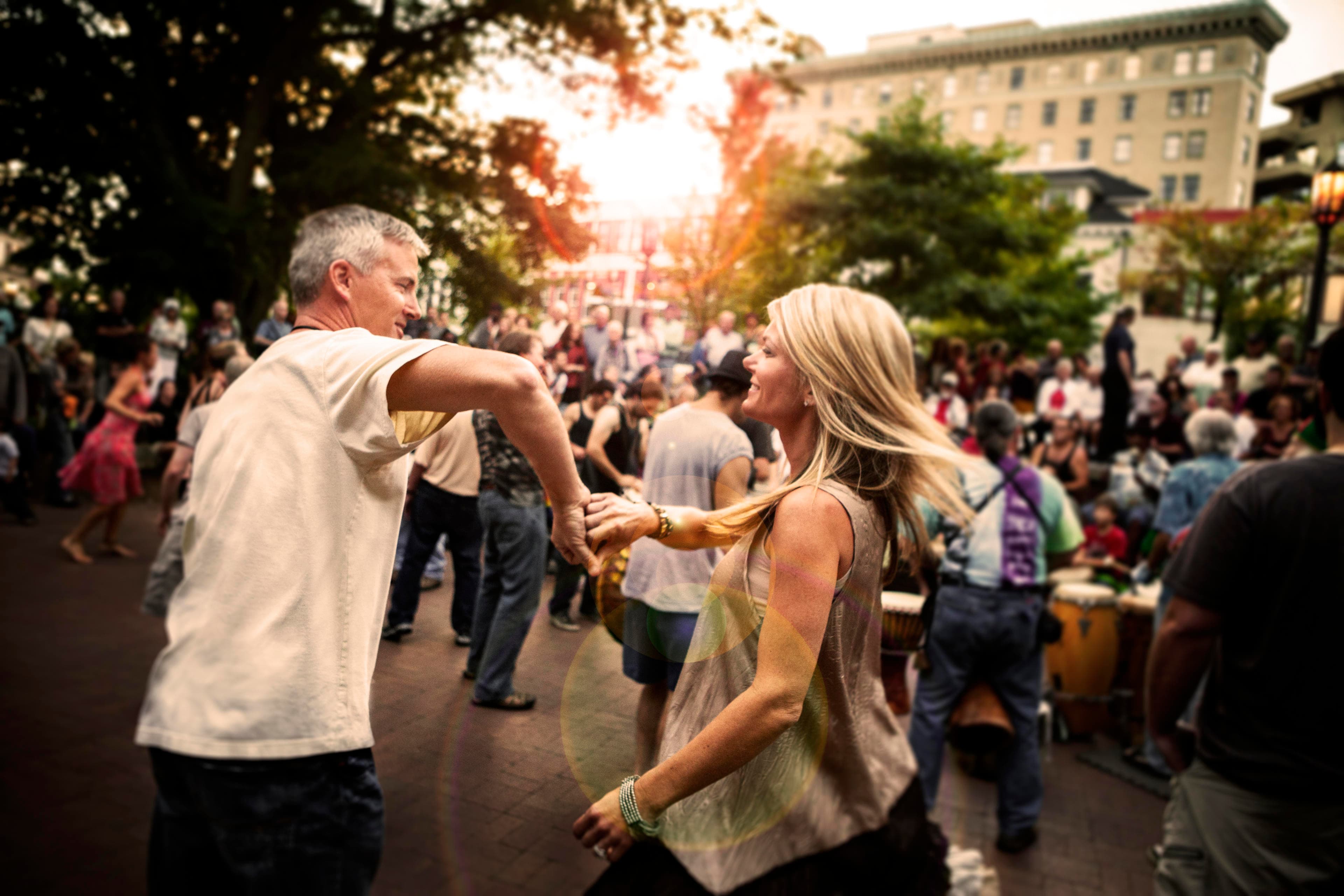 Where to Dance in Asheville two people smile as they dance in a square in Asheville