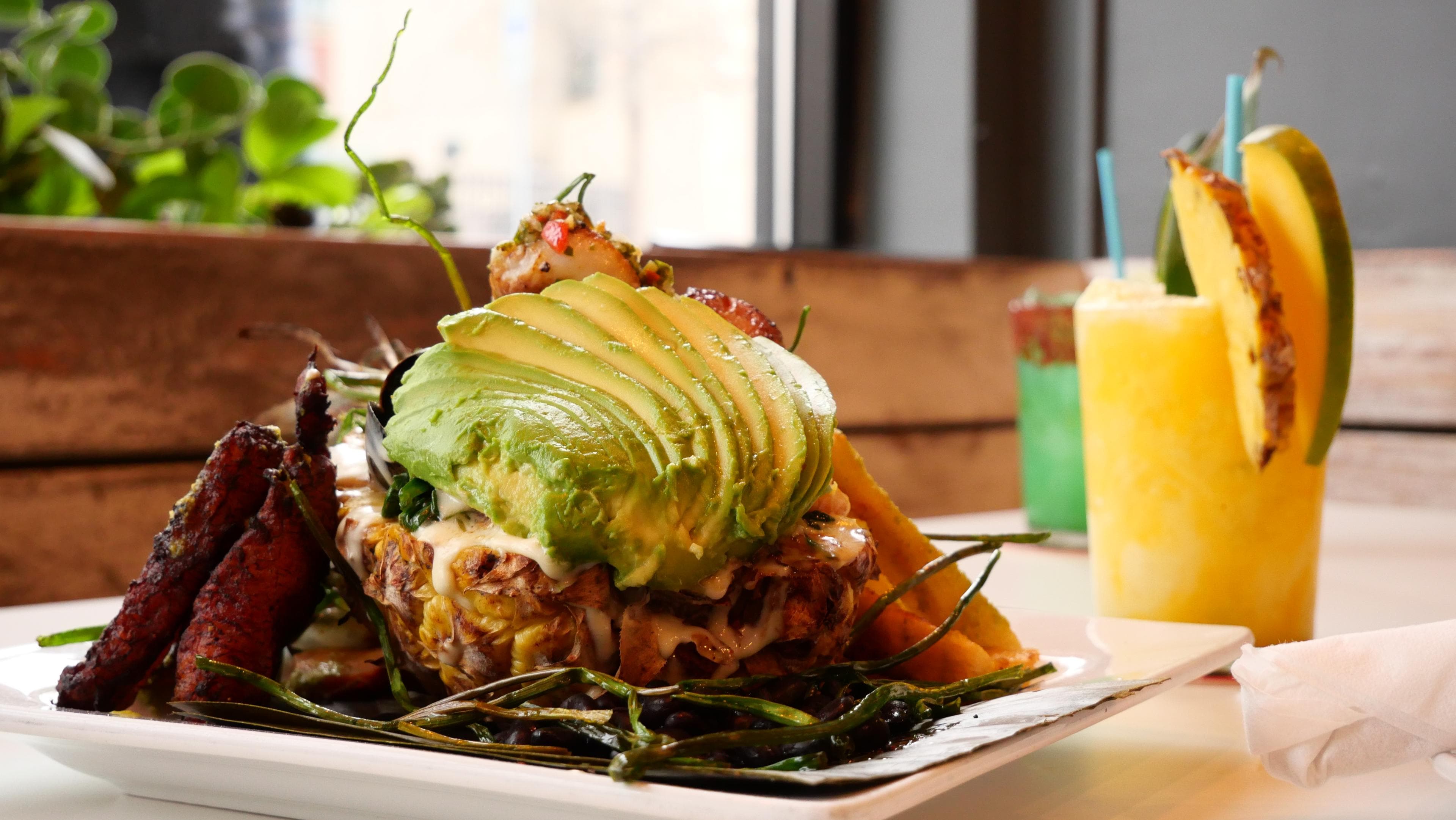 Asheville Authentic Latinx Food Scene: 20+ Latinx Food Spots A dish with avocado with a pineapple drink in the background
