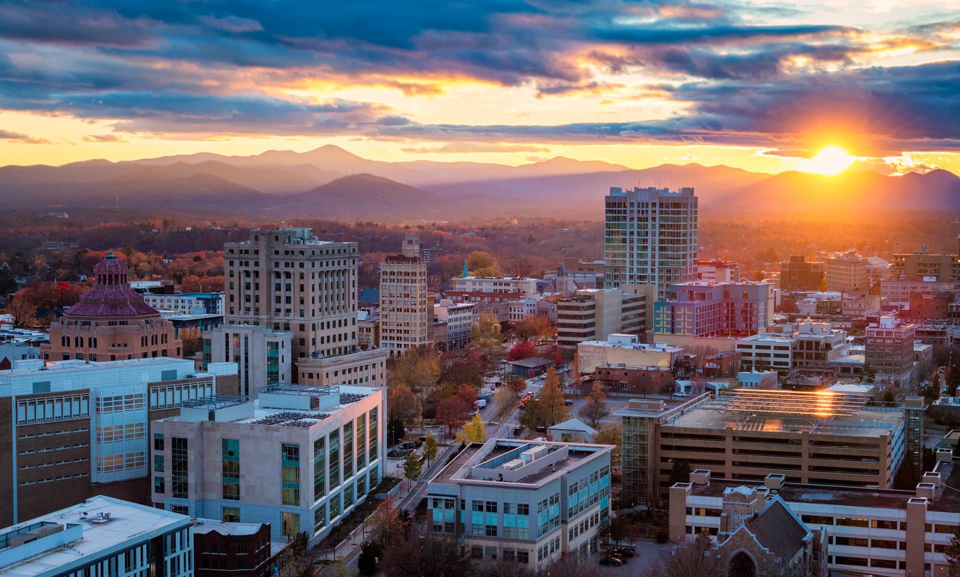 Budget-Friendly Tips for a Midweek Trip to Asheville The sun rises behind downtown Asheville